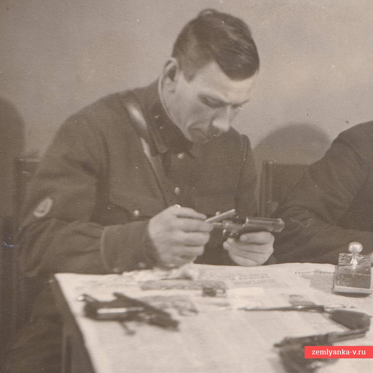 Фото сотрудника ГБ НКВД за чисткой пистолетов
